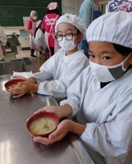 呉汁の入ったお椀を手に持つ子どもたちの様子