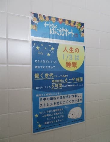 職場の休憩室の掲示板に健康かわらばんを掲示している様子