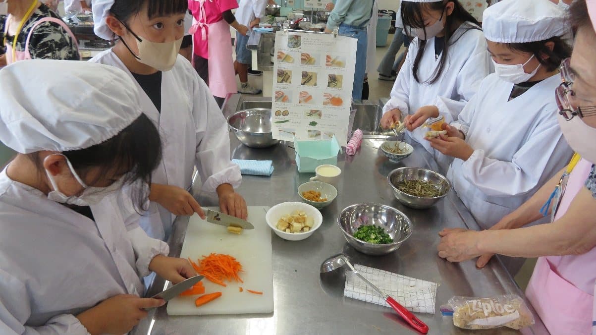 にんじんの千切りなど、材料を切る作業に取り組む子どもたちの様子