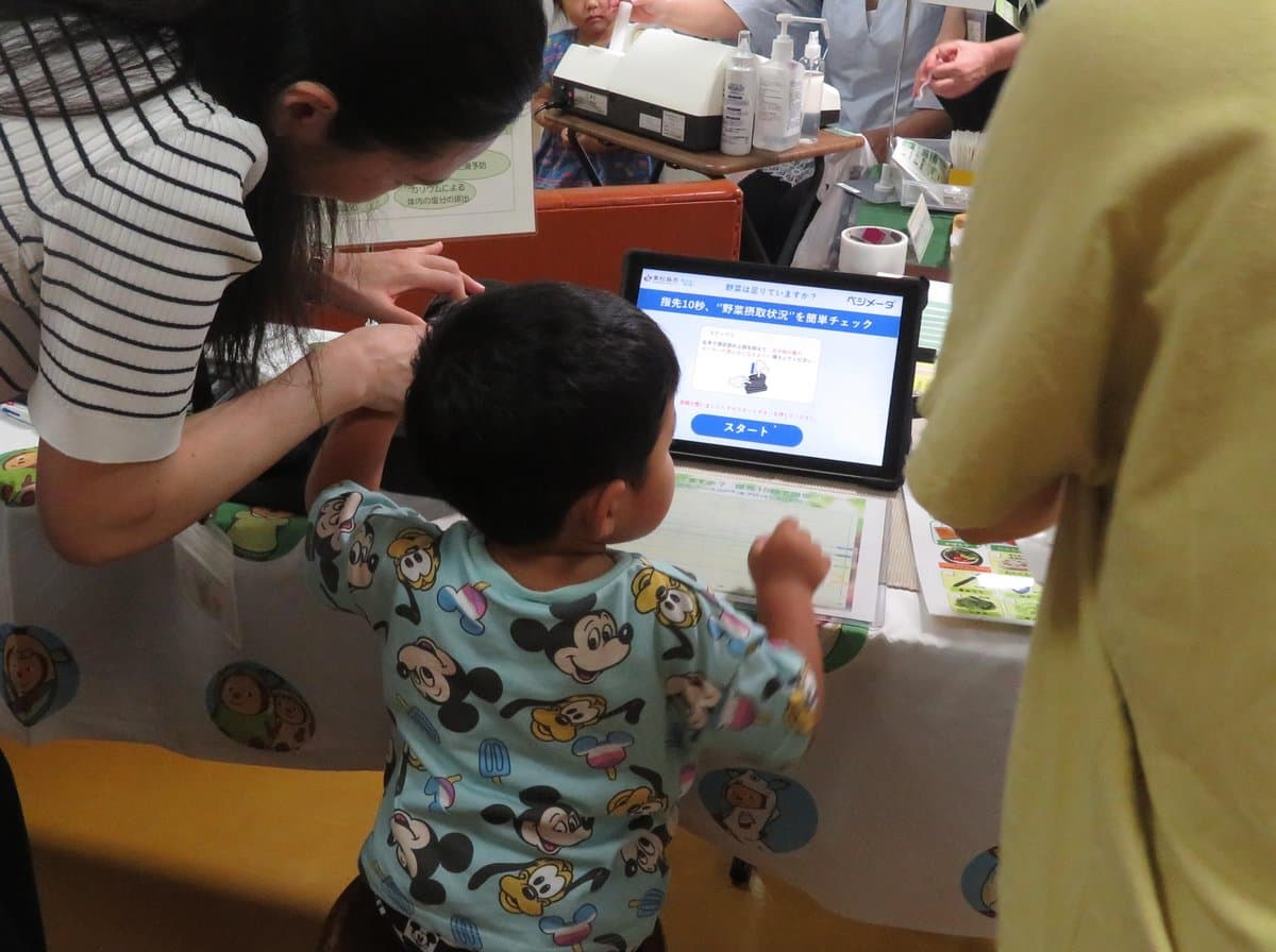 測定器の画面を見ながら測定を始める子ども