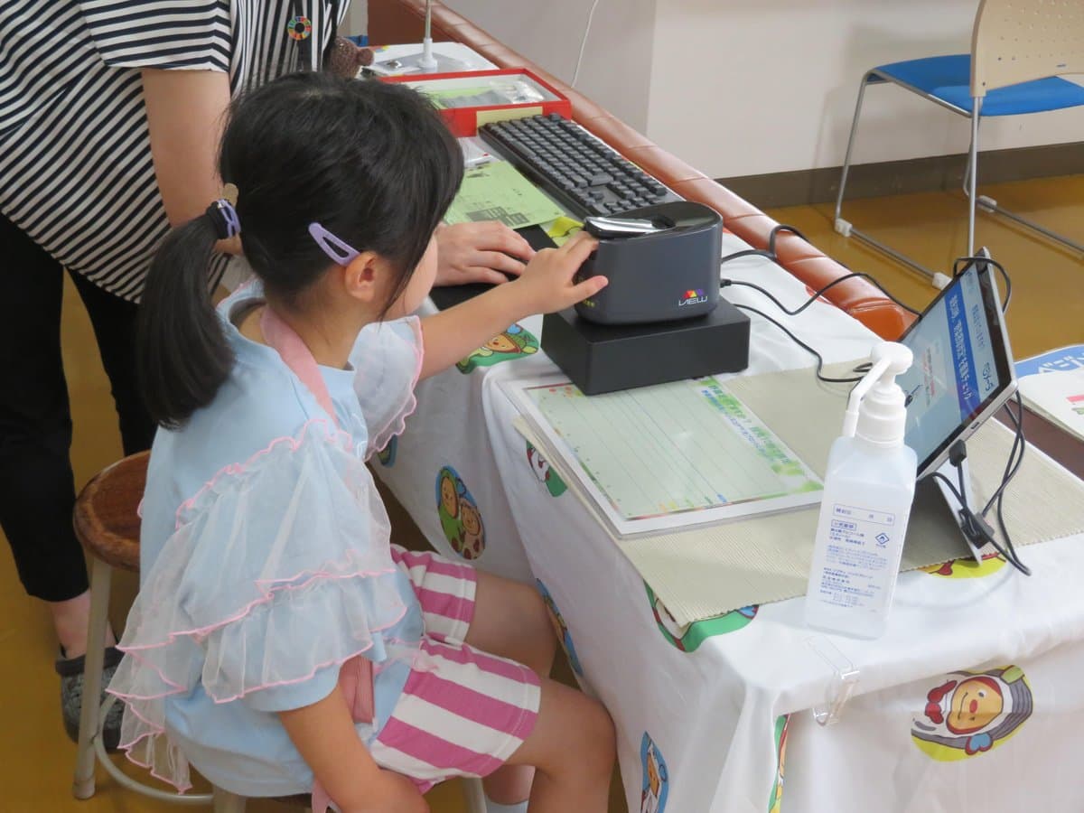測定器に指をのせて測定する子ども